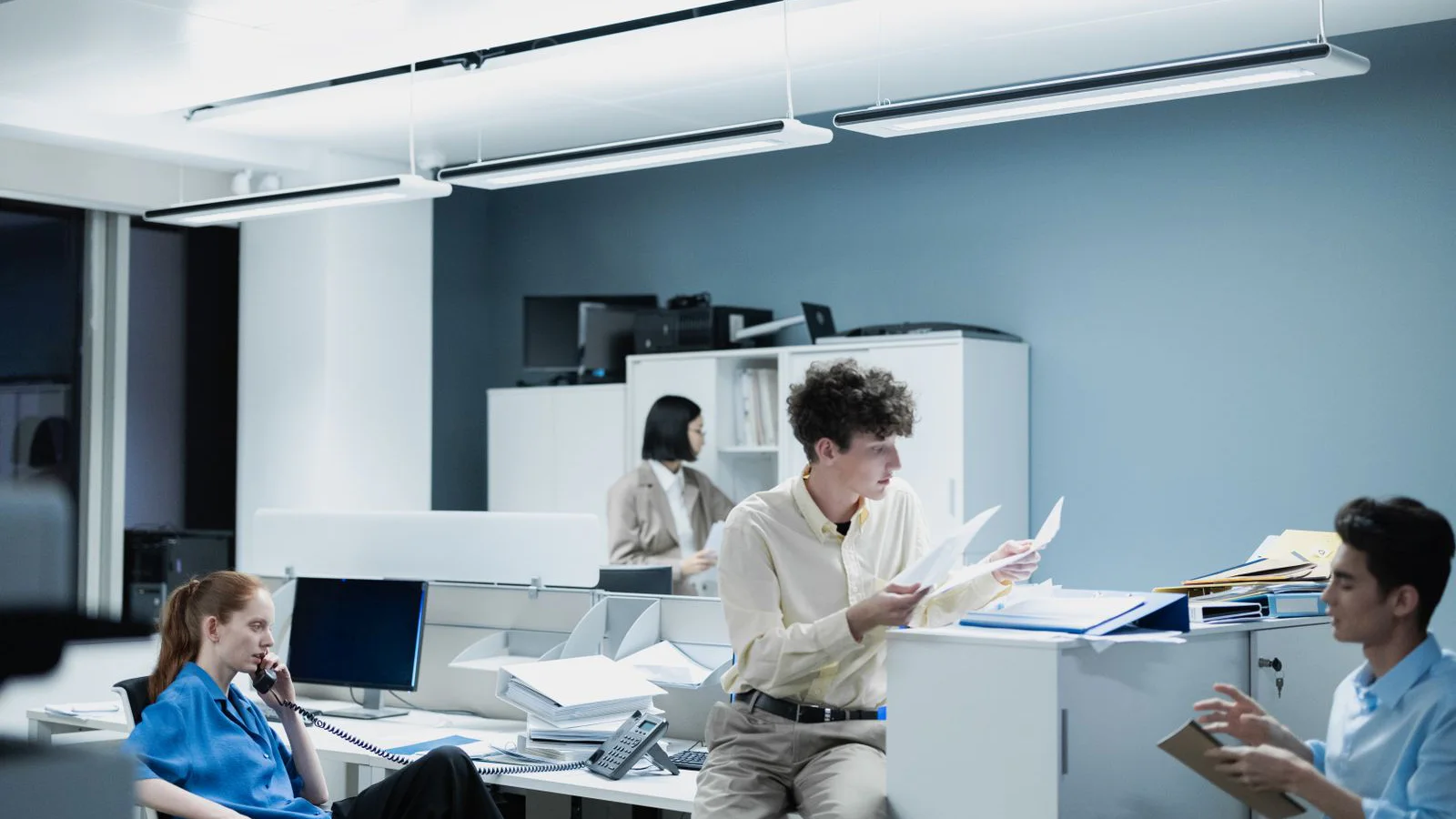 A professional office team coordinating documents in a shared workspace.